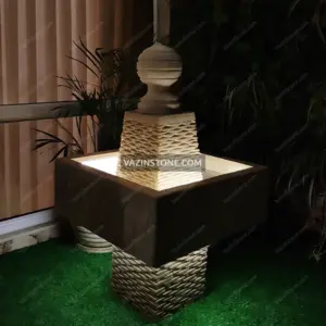 Square design stone fountain at night