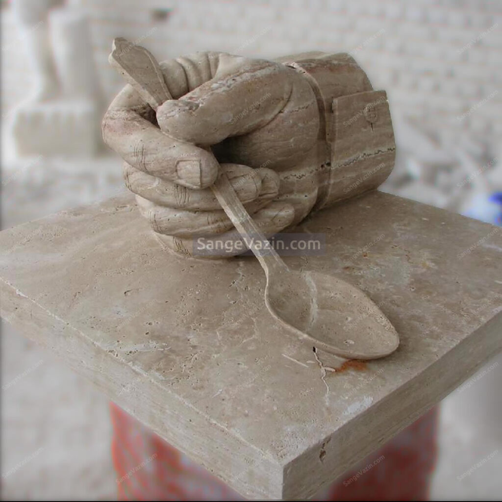 Stone sculpture of hands and spoons