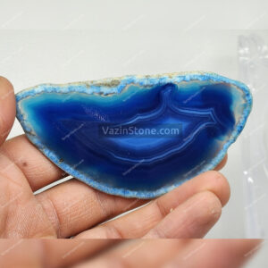 Smile shaped blue agate stone in hand