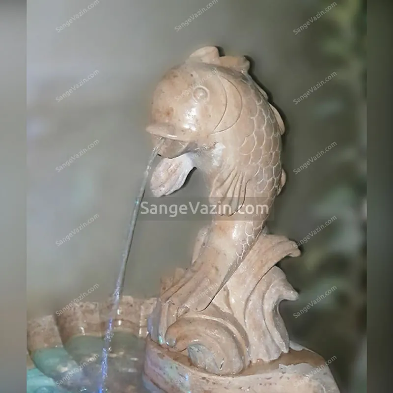 Fish and wave stone fountain`s water flow