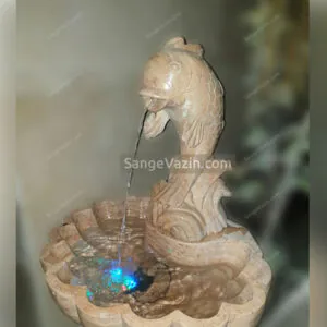 Fish and wave stone fountain`s water flow