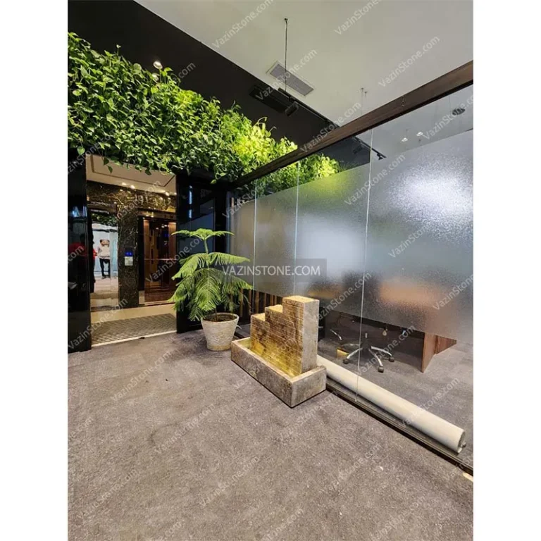 Three tak stone fountain with green wall